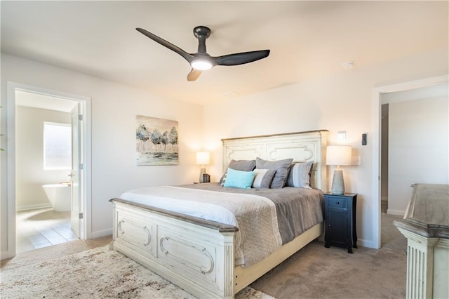 bedroom with ensuite bathroom, baseboards, ceiling fan, and light carpet
