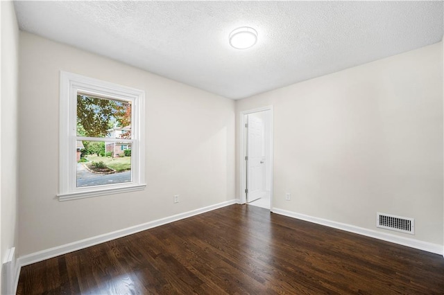 empty room featuring hardwood / wood-style flooring and a textured ceiling