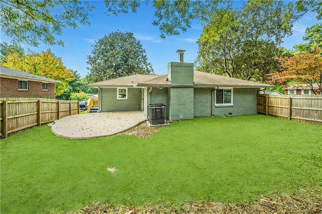 rear view of house with a lawn, cooling unit, and a patio area