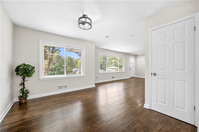 unfurnished living room with dark wood-type flooring