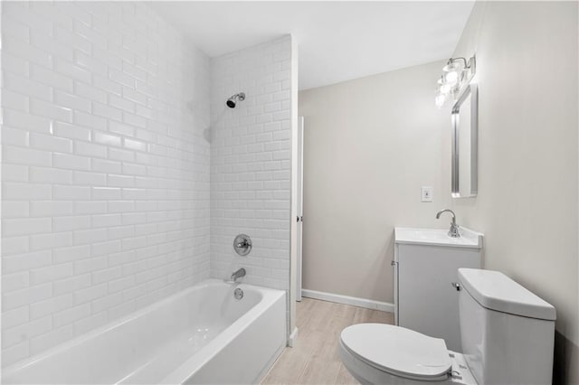 full bathroom with hardwood / wood-style flooring, vanity, toilet, and tiled shower / bath combo