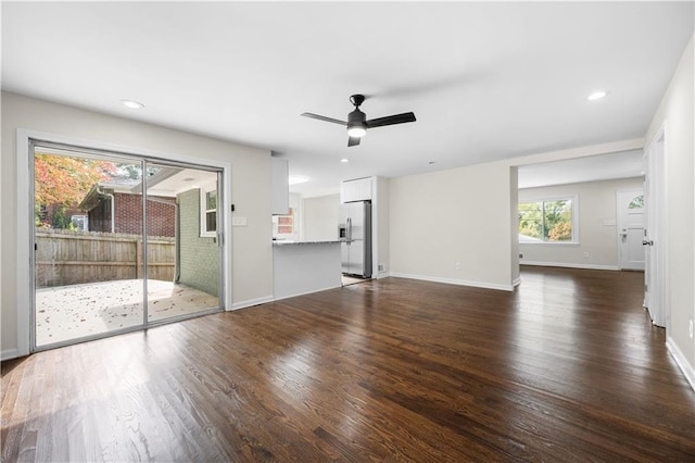 unfurnished living room featuring ceiling fan and dark hardwood / wood-style floors