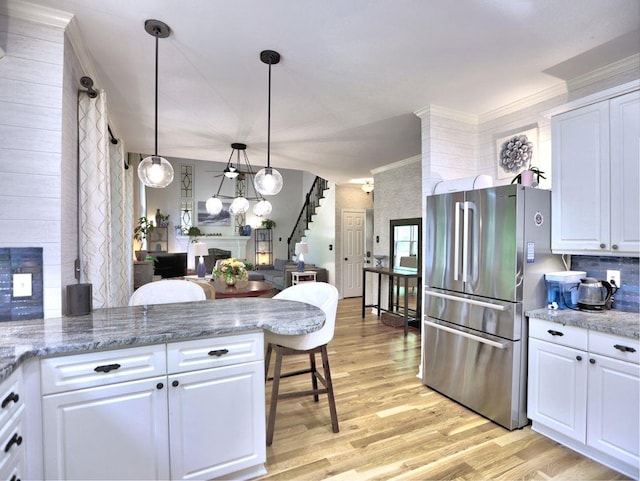 5105 Tynewick Trce NE, Roswell, GA 30075 - kitchen with freestanding refrigerator, light wood-style flooring, white cabinets, a peninsula, and crown molding