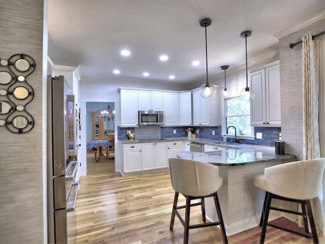 5105 Tynewick Trce NE, Roswell, GA 30075 - kitchen featuring stainless steel appliances, a sink, crown molding, a peninsula, and a kitchen breakfast bar