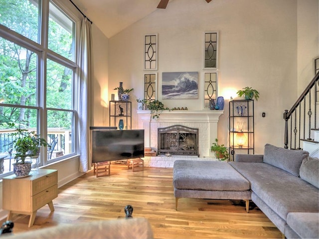 5105 Tynewick Trce NE, Roswell, GA 30075 - living room with wood finished floors, a brick fireplace, stairway, ceiling fan, and high vaulted ceiling