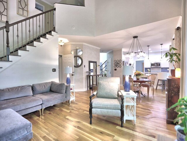 5105 Tynewick Trce NE, Roswell, GA 30075 - living area with stairs, light wood-style flooring, ornamental molding, a chandelier, and a high ceiling