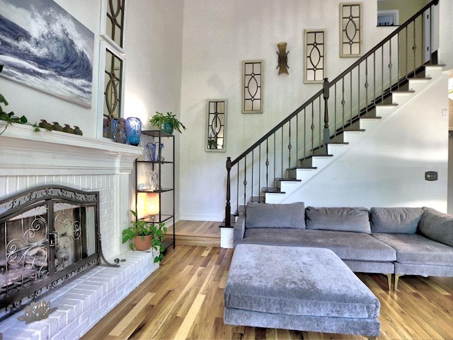 5105 Tynewick Trce NE, Roswell, GA 30075 - living area with a brick fireplace, stairs, wood finished floors, baseboards, and a high ceiling