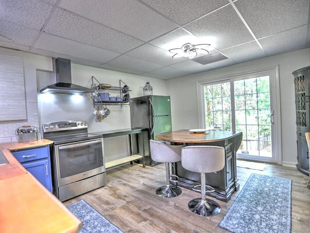5105 Tynewick Trce NE, Roswell, GA 30075 - kitchen featuring stainless steel electric range oven, wall chimney exhaust hood, a paneled ceiling, freestanding refrigerator, and light wood-style flooring