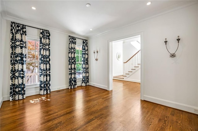 spare room with crown molding, wood finished floors, baseboards, stairway, and recessed lighting