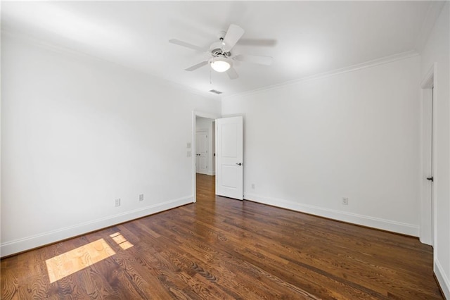 empty room featuring crown molding, dark wood-style floors, baseboards, and a ceiling fan