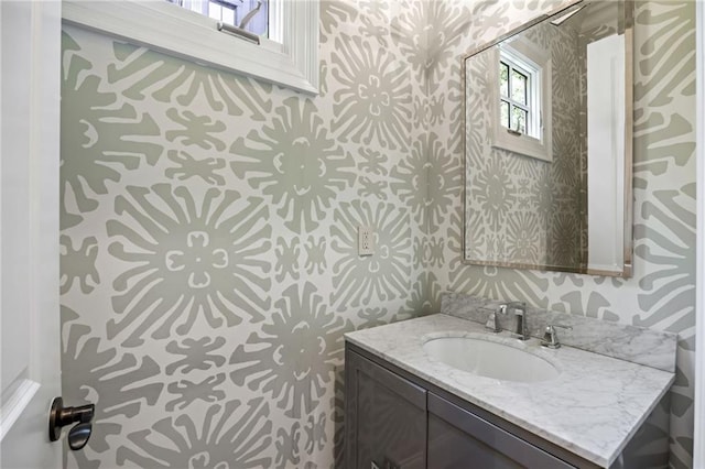 bathroom featuring wallpapered walls and vanity