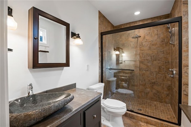 full bath with a stall shower, toilet, and vanity