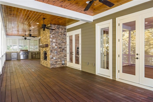 deck featuring french doors, a ceiling fan, and exterior kitchen