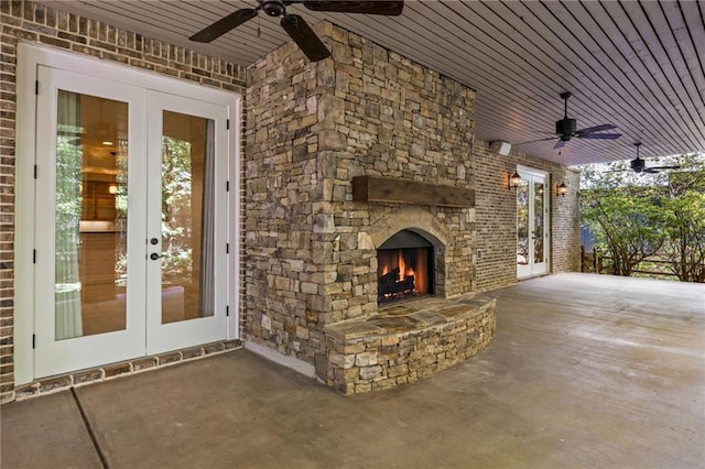 view of patio / terrace with french doors, ceiling fan, and an outdoor stone fireplace