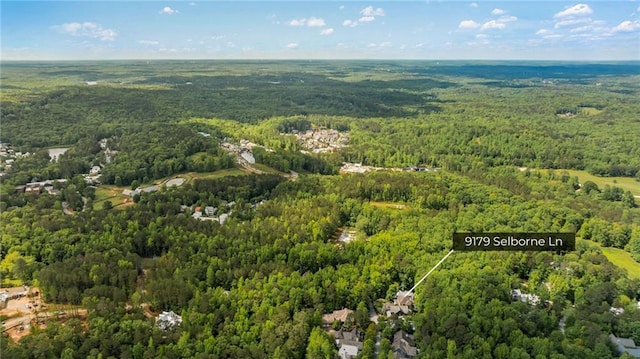 aerial view of property and surrounding area with a heavily wooded area