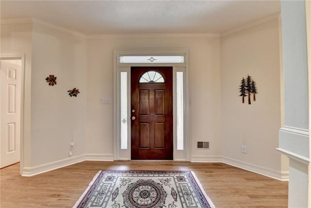 foyer with baseboards, visible vents, and wood finished floors