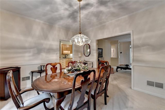 dining area with crown molding, light colored carpet, visible vents, and an inviting chandelier