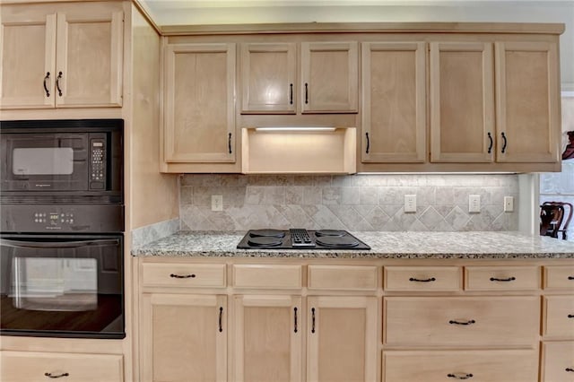 kitchen with backsplash, light brown cabinetry, black appliances, and light stone countertops