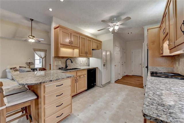 kitchen featuring a sink, light brown cabinets, a ceiling fan, and black appliances