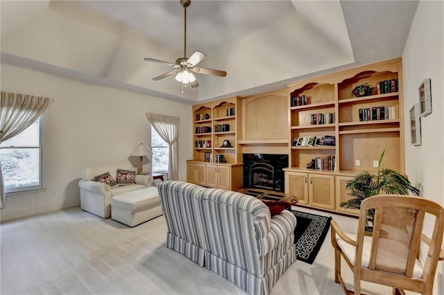 living room with ceiling fan, light carpet, a high end fireplace, and plenty of natural light