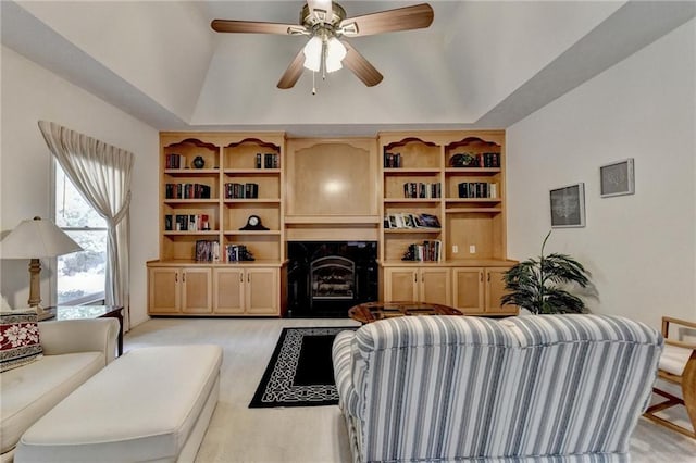 living room featuring a ceiling fan, a tray ceiling, a premium fireplace, and light carpet