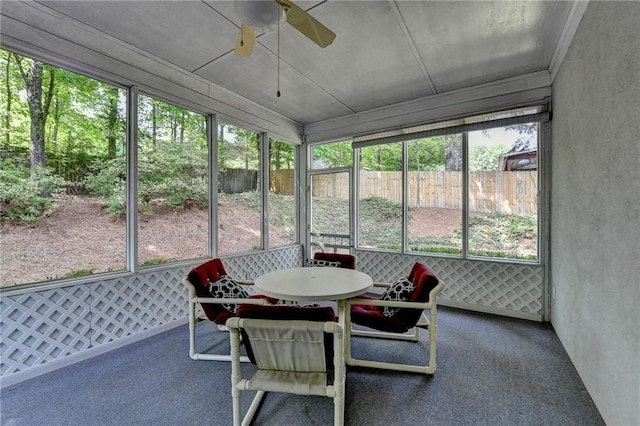 sunroom / solarium featuring a ceiling fan and outdoor dining area
