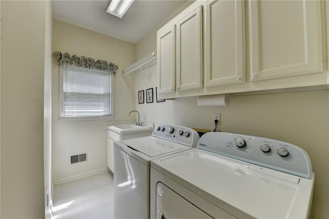 clothes washing area with visible vents, baseboards, separate washer and dryer, a sink, and cabinet space