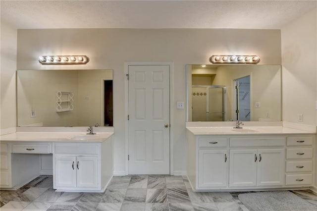 bathroom featuring a closet, a sink, two vanities, and a shower stall