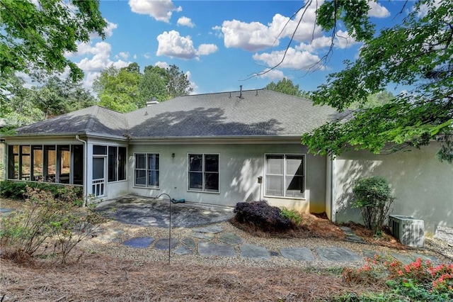 back of house with a sunroom, a shingled roof, a patio area, and stucco siding