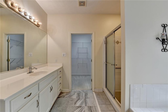 full bath featuring visible vents, baseboards, a stall shower, and vanity