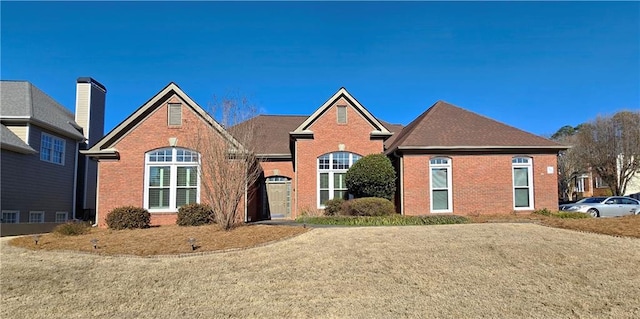 traditional-style home featuring a front yard and brick siding