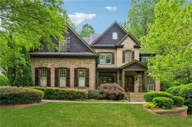 craftsman-style home with brick siding, a standing seam roof, and a front yard