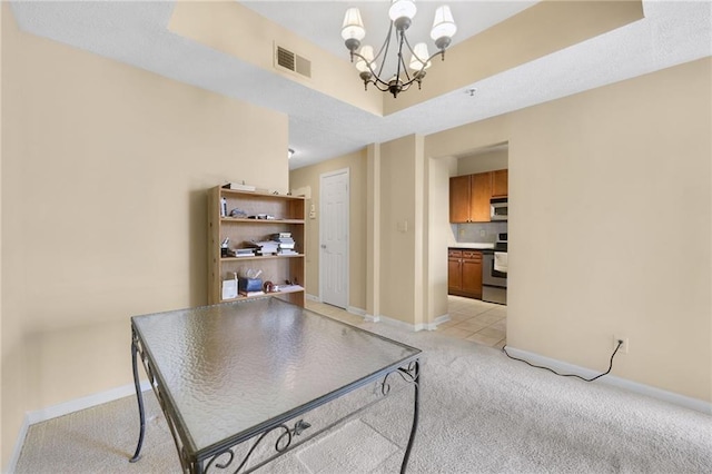 dining room with a raised ceiling, light colored carpet, and an inviting chandelier