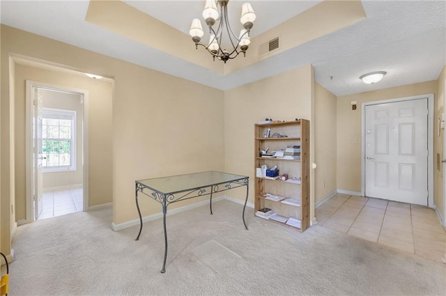 interior space featuring light carpet, a chandelier, and a tray ceiling