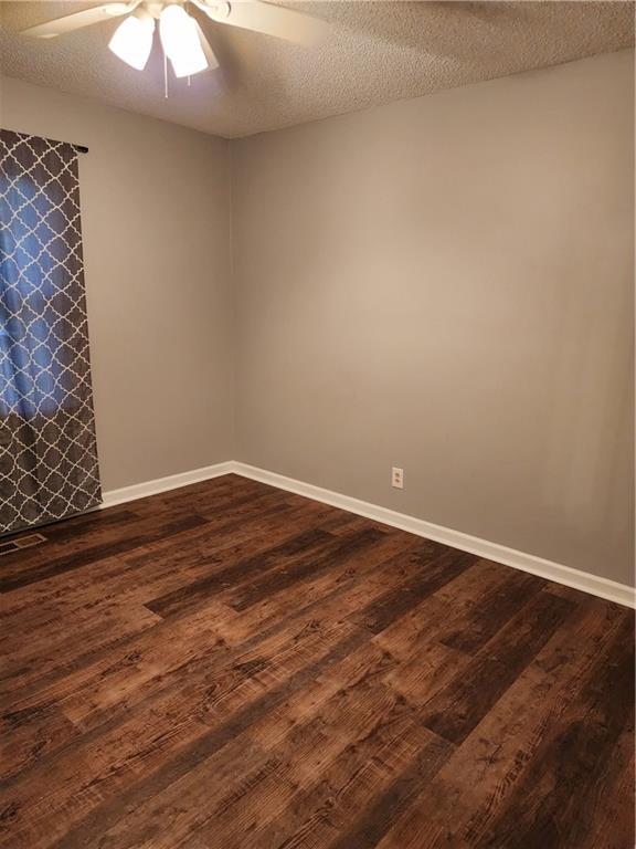 1751 Bridle Ln, Macon, GA 31220 - empty room with a ceiling fan, dark wood-type flooring, and a textured ceiling