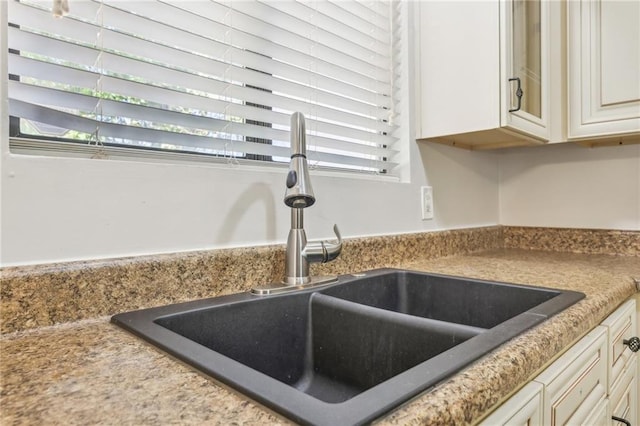 details featuring sink and cream cabinetry