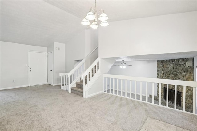 carpeted living room with ceiling fan with notable chandelier