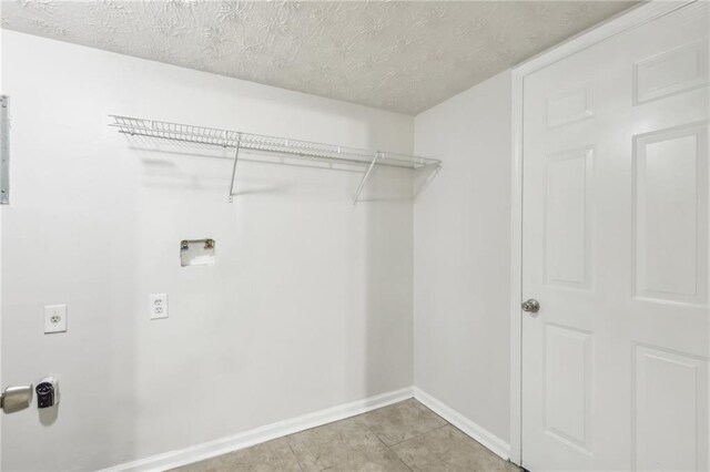 washroom featuring light tile patterned flooring, electric dryer hookup, a textured ceiling, and washer hookup