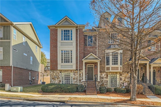 townhome / multi-family property featuring brick siding and stone siding