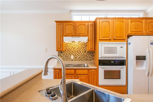 kitchen with under cabinet range hood, white appliances, backsplash, and ornamental molding