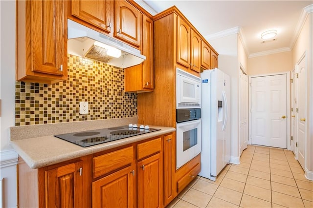 kitchen with under cabinet range hood, decorative backsplash, white appliances, light tile patterned floors, and ornamental molding