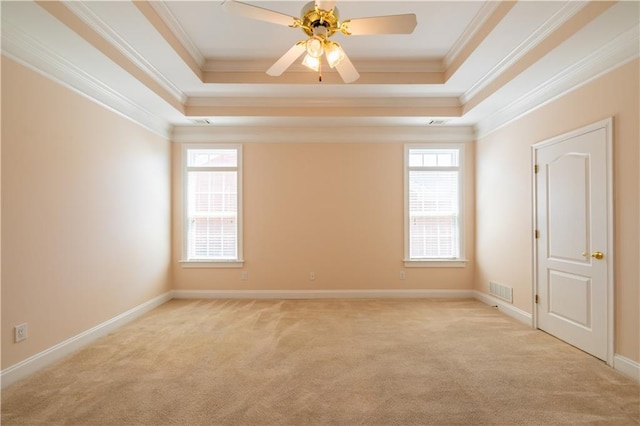empty room with light colored carpet, crown molding, a tray ceiling, and visible vents