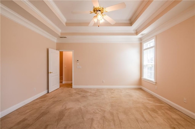 empty room featuring light colored carpet, crown molding, and a raised ceiling