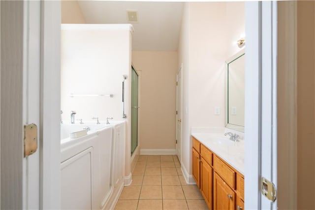 bathroom with vanity, baseboards, tile patterned flooring, and a stall shower