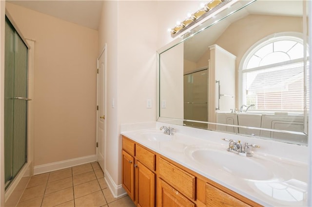 bathroom with tile patterned flooring, a sink, a shower stall, and double vanity