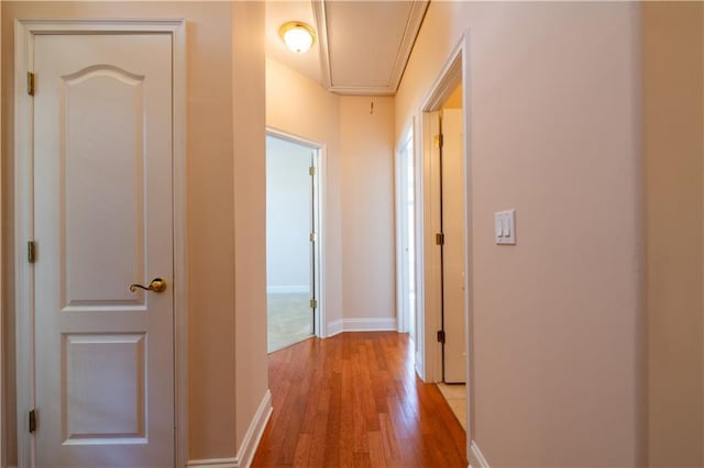 hallway with attic access, light wood-type flooring, and baseboards