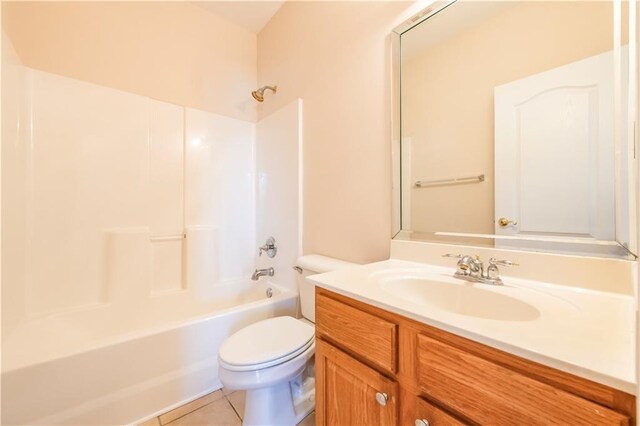 bathroom featuring vanity, toilet, tile patterned flooring, and shower / bathing tub combination