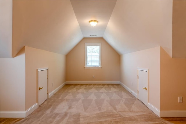additional living space with light colored carpet, lofted ceiling, and baseboards