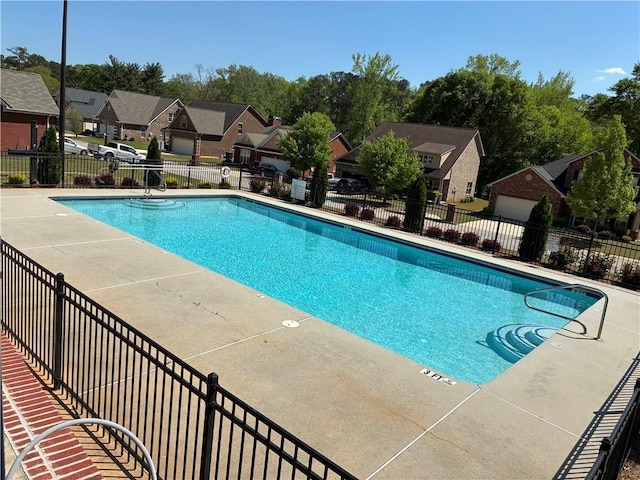 community pool with fence and a residential view