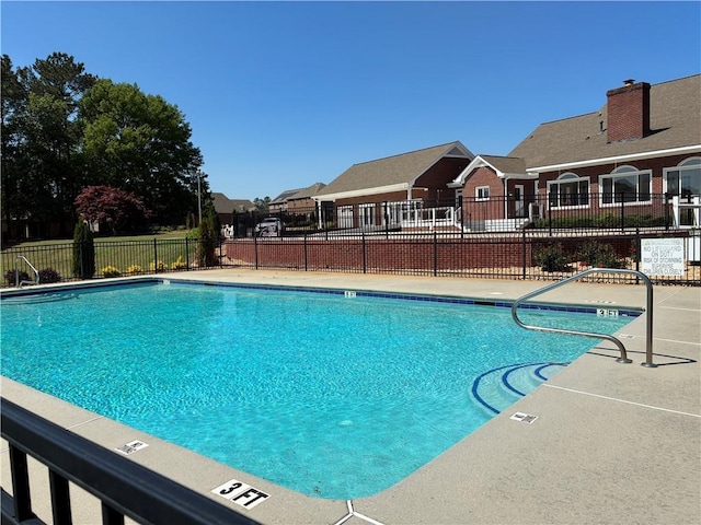 community pool with fence and a residential view